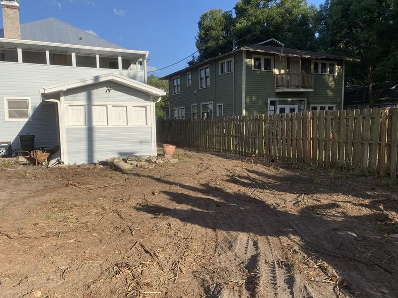 Backyard cleared back to dirt around an outbuilding.